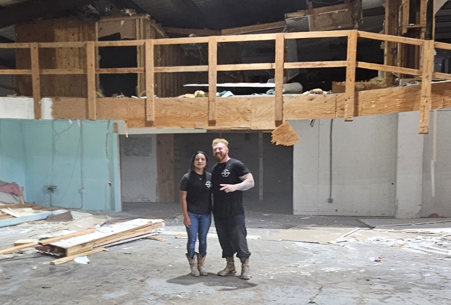 JT Junk Solutions founders standing inside a commercial space stripped to the studs during an interior demolition