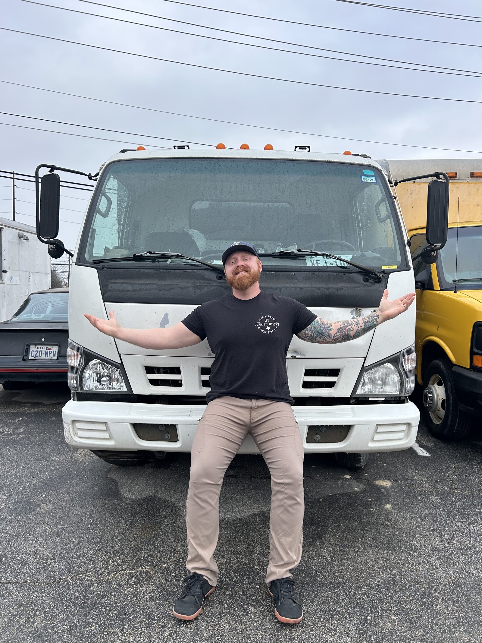 Tanner standing in front of the JT Junk Solutions truck cab
